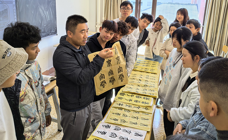 徐润刚用手语为学生们讲解书法篆刻。云南特殊教育职业学院供图